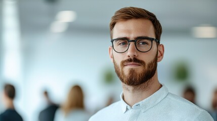 Confident young man with glasses in modern office setting, showcasing professionalism and focus in a business environment.