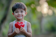 © Gema Vélez - small asian boy very smiling with a heart in his hands.goodwill day.
