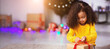 © Prostock-studio - My gift. Concentrated little african girl opening holiday present on Christmas Eve, free space
