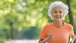 © t.sableaux - Active senior woman jogs on a sunny day in a green park, healthy and active lifestyle