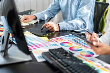 Poster - Two creative graphic designer team working on color selection and drawing on graphic tablet, Color swatch samples chart for selection coloring in inspiration to creativity at workplace