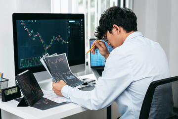 Wall Mural - Businessman investor working and stress with computer analyzing graph stock market trading planning with chart data financial investment planning