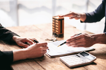 Aufkleber - Two people are sitting at a table with a pen and a calculator
