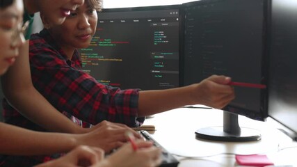 Slow motion back end software developer engineer for computer programming working together on debugging writing computing code, solving complex algorithms display on monitor in office. Burgeoning