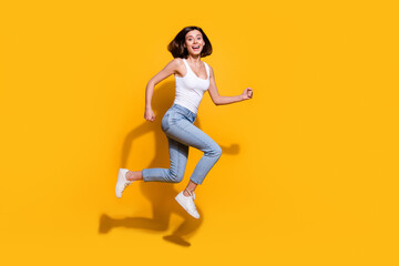 Canvas Print - Full body photo of attractive young girl running hurry shopping wear trendy white outfit isolated on yellow color background