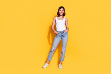 Poster - Full body photo of attractive young girl hands pockets posing wear trendy white outfit isolated on yellow color background