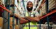© peopleimages.com - Black man, arms crossed and happy in warehouse on portrait for manufacturing as manager in Uganda. Male person, employee and smile with confidence at wholesale for package, supply chain and delivery