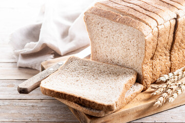 Healthy wholemeal bread slices isolated on wooden table