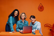© Jacob Lund - Diverse team of co-workers happily posing in vibrant office with laptop and colourful backgrounds