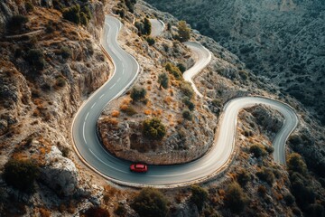 Car driving on a serpentine road. Curvy road surrounded by pine forest. Top view