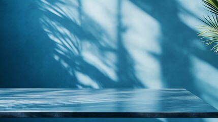 Poster - bright blue wall with intricate shadows and a green plant beside a sleek surface in a sunlit room