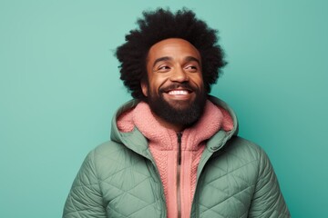 Sticker - Portrait of a joyful afro-american man in his 40s sporting a quilted insulated jacket on pastel teal background