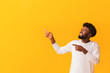© Prostock-studio - Happy african guy pointing at copy space over orange background, showing amazing offer, panorama