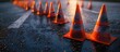 © StockKing - High quality picture of a row of bright orange traffic cones on dark asphalt with ample copy space image