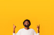 © Prostock-studio - Shocking sale. Positive afro guy looking and pointing up at free space over orange background