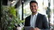 ©  premium content - Happy Young Latin Businessman Executive Holding a Laptop in a Modern Office Environment for Professional Use and Inspirational Content