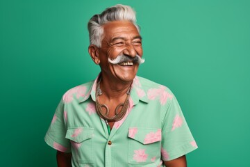 Wall Mural - Portrait of a joyful indian man in his 80s sporting a vintage band t-shirt in soft green background