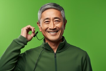 Poster - Portrait of a satisfied asian man in his 60s wearing a thermal fleece pullover over soft green background