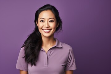 Wall Mural - Portrait of a smiling asian woman in her 30s wearing a sporty polo shirt on soft purple background