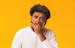 © Prostock-studio - No way. Amazed afro man with widely opened eyes covering his mouth with palm over orange background