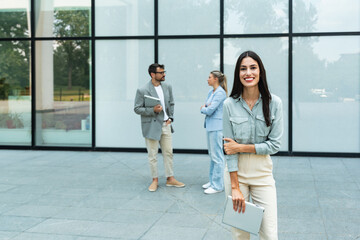 Portrait of happy smiling confident female leader businesswoman standing outside the modern office building workplace looking at camera. Professional business successful executive concept.