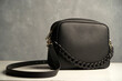 © Gecko Studio - Stylish women's bag on gray background. Black leather handbag, close-up
