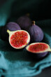 © TatjanaMeininger - Close up of fresh ripe fig fruits in green fabric with dark shadows