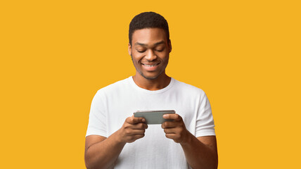 Aufkleber - Messaging At Social Network. Happy black man using mobile phone over orange wall, copypace, panorama