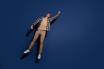 Wall Mural - Full length photo of handsome good mood guy wear checkered shirt jumping high catching emtpy space isolated blue color background