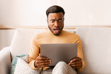 Aufkleber - Error. Shocked African American Man Looking At Laptop Screen Sitting On Sofa At Home. Selective Focus