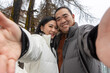 © ADDICTIVE STOCK - Asian couple taking a selfie in snowy Zermatt during Christmas