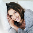 © Sanc/peopleimages.com - Woman, home and smile in bed on portrait in morning with waking up on break, rest and relax. Me time, female person and happy or laughing in confidence on day off to chill for self care in Canada