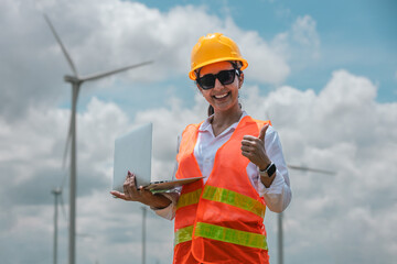 Fototapete - Renewable energy systems concept, engineer female using laptop working wind turbine for alternative energy, Technology protect environment reduce global warming problems. Woman smile thumb up.