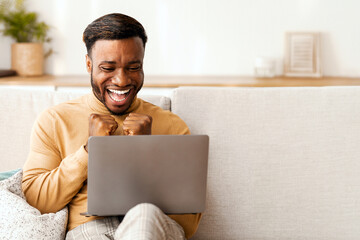 Aufkleber - Success. Happy Black Guy Shaking Fists Looking At Laptop Screen Sitting On Couch At Home. Free Space