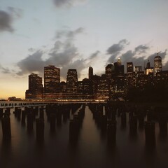 New York City skyline at dusk with wooden pilings