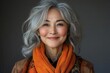 © julija - joyful portrait of a mature asian woman laughing heartily radiating positivity and vitality against a soft gray backdrop
