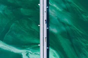 Wall Mural - Aerial drone view of asphalt road bridge with cars and truck over turquoise blue water river sea ocean. Amazing summer landscape.