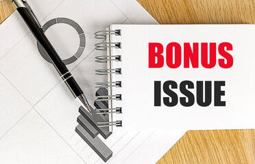 Poster - Notepad with bonus issue text and pen on a desk with financial charts