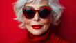 © Anna - Portrait of a Stylish Senior Woman with Silver Hair, Red Lips, and Sunglasses on a Red Background
