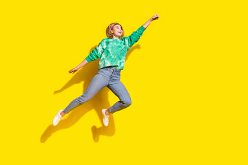 Sticker - Full length photo of cheerful pretty lady dressed green sweatshirt jumping high rising fist empty space isolated yellow color background