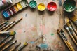 © StockUp - An artist's workspace showing a variety of vibrant paints and brushes spread across a rustic wooden table, creativity abounds.