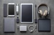 © Four888 - Sleek grey surface showcases modern electronics ensemble: dual smartphones, tablet, wireless headphones, stylus, power bank, and accessories, artfully arranged in a flat lay design.