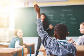 Poster - Little boy, hands raised and classroom with question for teacher, answer or learning at elementary school. Back view, kid or young child with answer for interaction, engagement or attention in lesson