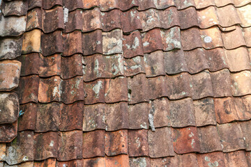 Poster - Close-up texture of an old, weathered tile roof. The tiles are brown, red, and orange with a rustic and worn appearance. Detail of Old Tile Roof Texture Background.