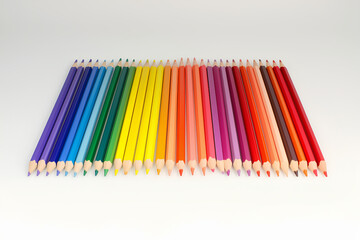 Poster - colored pencils arranged in a gradient from red to violet on a white background