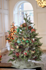 small Christmas tree made of white needles decorated with roses and birds in pink colors in romantic style