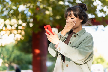 Pretty woman caught watching video on mobile phone. Lifestyle concept.