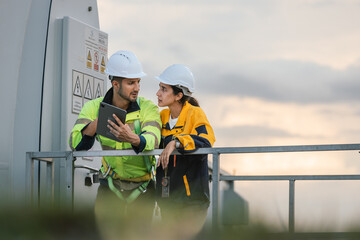 Fototapete - Team engineer wind turbine worker safety uniform survey discuss operational planning windmill field clean energy. Alternative technology protect environment reduce global warming problems.