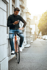 Canvas Print - Bike, phone and online with man in city for communication, social media or connection. Networking, newsletter and location app with person and mobile in downtown for travel, digital or internet