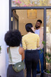 © wavebreak3 - Greeting friends at doorway, man smiling and welcoming two women into home
